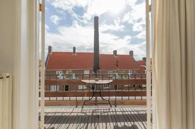an open door to a balcony with a view of a building at Zandvoortferienwohnungen in Zandvoort