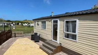a tiny house with a porch and a patio at Chalet Playa direct aan zee in IJmuiden in IJmuiden