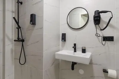 a bathroom with a sink and a mirror at Haarlem Apart Hotel in Haarlem