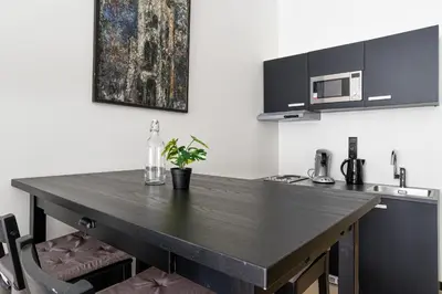 a kitchen with a black counter top in a room at Haarlem Apart Hotel in Haarlem