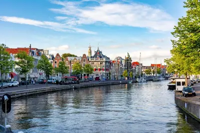 a river in a city with buildings and cars at Haarlem Apart Hotel in Haarlem