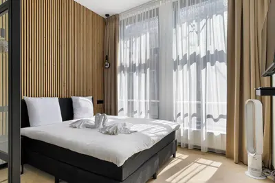 a bedroom with a bed and a large window at Haarlem Apart Hotel in Haarlem