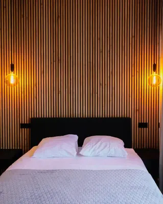 a bedroom with a bed with two pillows and two lights at Haarlem Apart Hotel in Haarlem