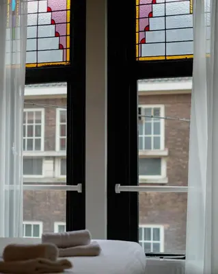 a bedroom with a window with a view of a building at Haarlem Apart Hotel in Haarlem