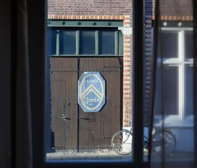 a sign on a wooden door on a building at Darley's in Hilversum