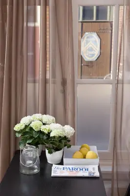 a table with flowers and a box of lemons and a window at Darley's in Hilversum