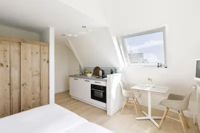 a kitchen with a small table and a kitchen with a window at Villa Parnassia in Bergen aan Zee
