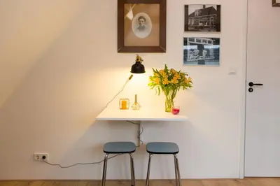 a table in the corner of a room with two stools at At the Butchers in Amsterdam