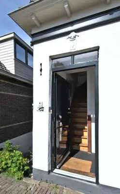 an open door of a house with a staircase at At the Butchers in Amsterdam