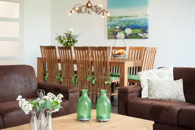 a living room with two green vases on a table at Newhouse Logies in Zevenhoven