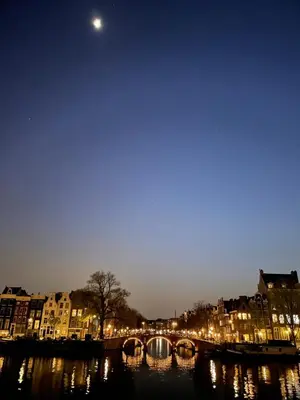 a bridge over a river in a city at night at Houseboat Sophia in Amsterdam
