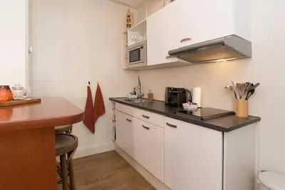 a kitchen with white cabinets and a counter top at Luttik Oudorp 30 in Alkmaar