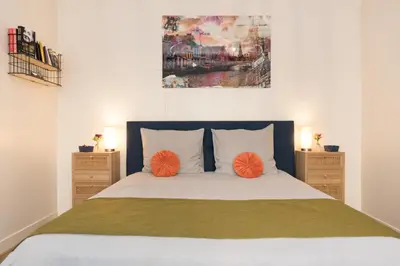 a bedroom with a bed with two orange pillows at Luttik Oudorp 30 in Alkmaar