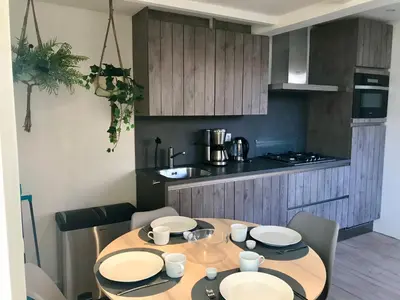 a kitchen with a wooden table with plates on it at Ferienhaus Genießen am Meer mit Wellnesszugang in Egmond aan Zee