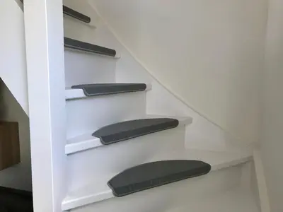 a stairway with black cushions on the shelves at Ferienhaus Genießen am Meer mit Wellnesszugang in Egmond aan Zee
