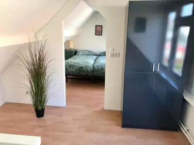 a bedroom with a bed and a black cabinet at Ferienhaus Genießen am Meer mit Wellnesszugang in Egmond aan Zee