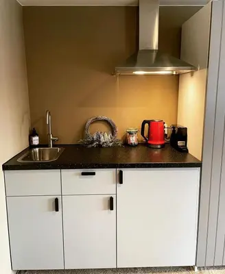 a kitchen with white cabinets and a sink at Amster Houseboat in Amsterdam