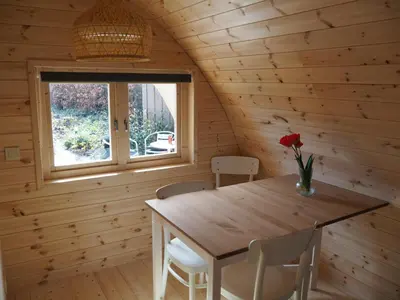 a dining room with a wooden table and a window at Polderlodge in Hillegom