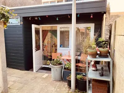 a black shed with potted plants on a patio at King almost by the sea in Zandvoort