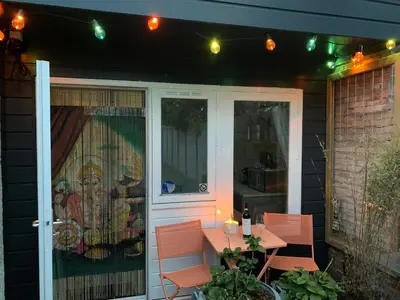 a patio with a table and a door with lights at King almost by the sea in Zandvoort