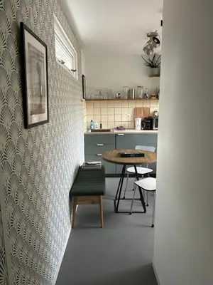 a kitchen with a table and a chair in a room at King almost by the sea in Zandvoort