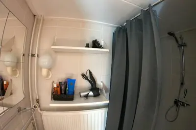 a bathroom with a shower with a shower curtain at Zomerhuis At Sea op top locatie in Egmond aan zee in Egmond aan Zee