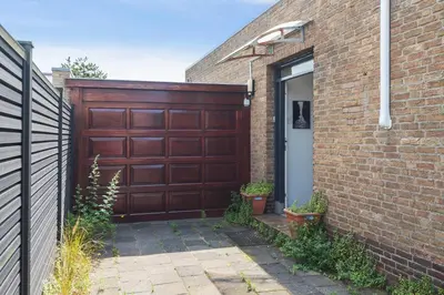 a brown garage door on a brick house at Apartment De Drie Tulpen in Zandvoort