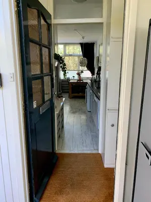 a hallway leading to a kitchen with a door at Amsterdam Beach Apartment 2, Private Garden in Zandvoort