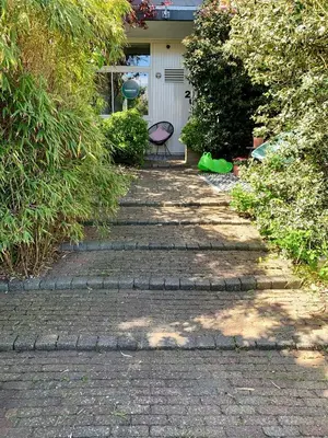 a brick walkway with a chair in front of a house at Amsterdam Beach Apartment 2, Private Garden in Zandvoort