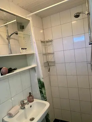 a white bathroom with a sink and a shower at Amsterdam Beach Apartment 2, Private Garden in Zandvoort