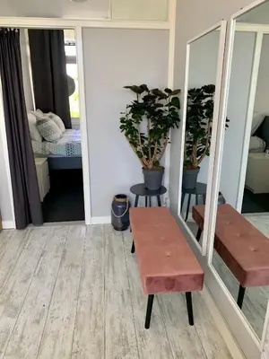 a room with a bench and a table and mirror at Amsterdam Beach Apartment 2, Private Garden in Zandvoort