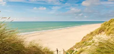 a sandy beach with the ocean in the background at Beachhouse Wijk aan Zee 6 guests near beach free parking in Wijk aan Zee