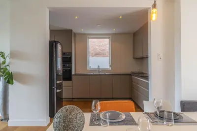 a kitchen with a table and chairs and a sink at Beachhouse Wijk aan Zee 6 guests near beach free parking in Wijk aan Zee