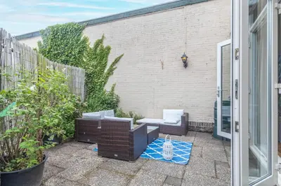 a small patio with a chair and a table at Beachhouse Wijk aan Zee 6 guests near beach free parking in Wijk aan Zee
