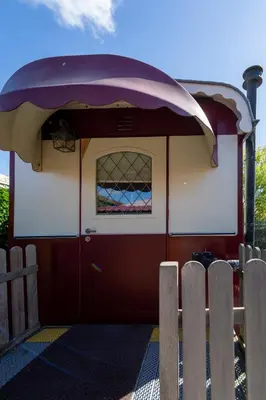 a train car with a red door and a window at De Wagen in Egmond-Binnen