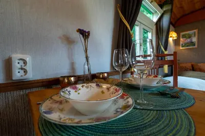 a table with a bowl and two glasses on it at De Wagen in Egmond-Binnen