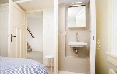a small bathroom with a sink and a mirror at 'T Sterntje in Bergen aan Zee