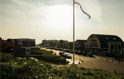 a city street with cars parked in a parking lot at 'T Sterntje in Bergen aan Zee