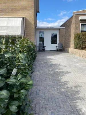 a building with a patio with two chairs on it at Little Buddha in Zandvoort
