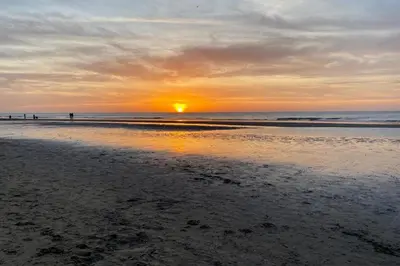 a sunset on a beach with the sun setting at Little Buddha in Zandvoort