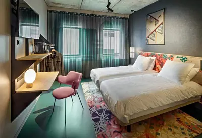 a hotel room with two beds and a couch at The Florian Amsterdam Schiphol Airport, WorldHotels Crafted in Hoofddorp