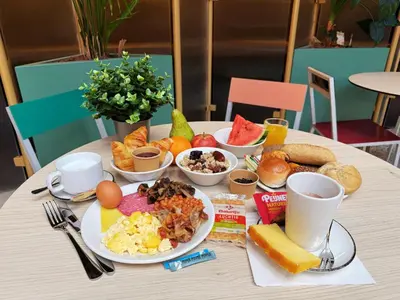a table with a plate of breakfast food on it at The Florian Amsterdam Schiphol Airport, WorldHotels Crafted in Hoofddorp