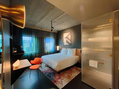 a hotel room with a bed and a bathroom at The Florian Amsterdam Schiphol Airport, WorldHotels Crafted in Hoofddorp