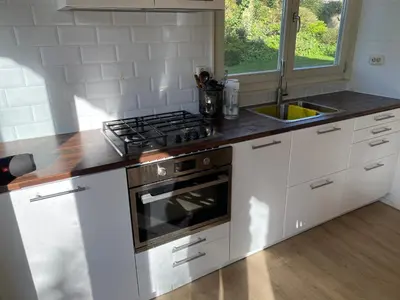 a kitchen with a stove and a sink at Garden find zandvoort in Bentveld