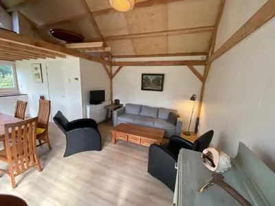 a living room with a couch and a table at Garden find zandvoort in Bentveld
