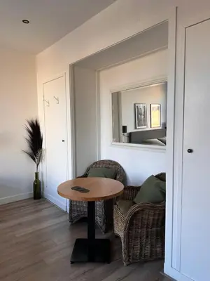 a room with a table and chairs and a mirror at Studio Wijkhuizen in Zandvoort