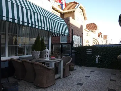 a patio with a table and chairs and a building at Studio Wijkhuizen in Zandvoort