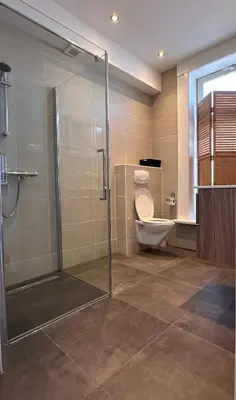 a bathroom with a toilet and a glass shower at Studio Wijkhuizen in Zandvoort