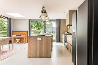 a kitchen with a wooden island and a table at Villa Merici in Bergen
