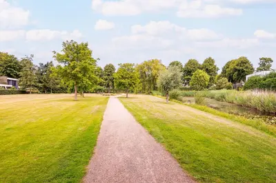 a path through a park with grass and trees at Villa Merici in Bergen